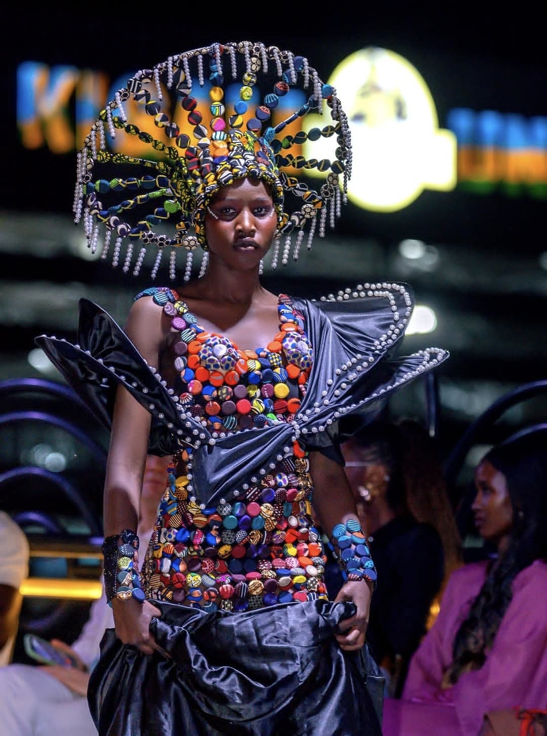 A model in a beaded crown and a multicolored beaded bodice on the runway