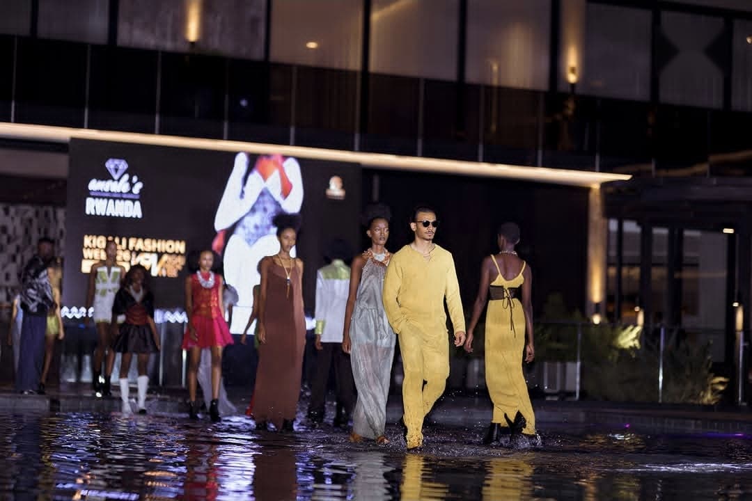 Models in color-blocked looks walk the runway together at night